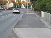 Bild 2: Die Gehwegoberfläche ist für den Radverkehr ungeeignet, zudem stehen Laternen- und Ampelmasten auf dem Weg.